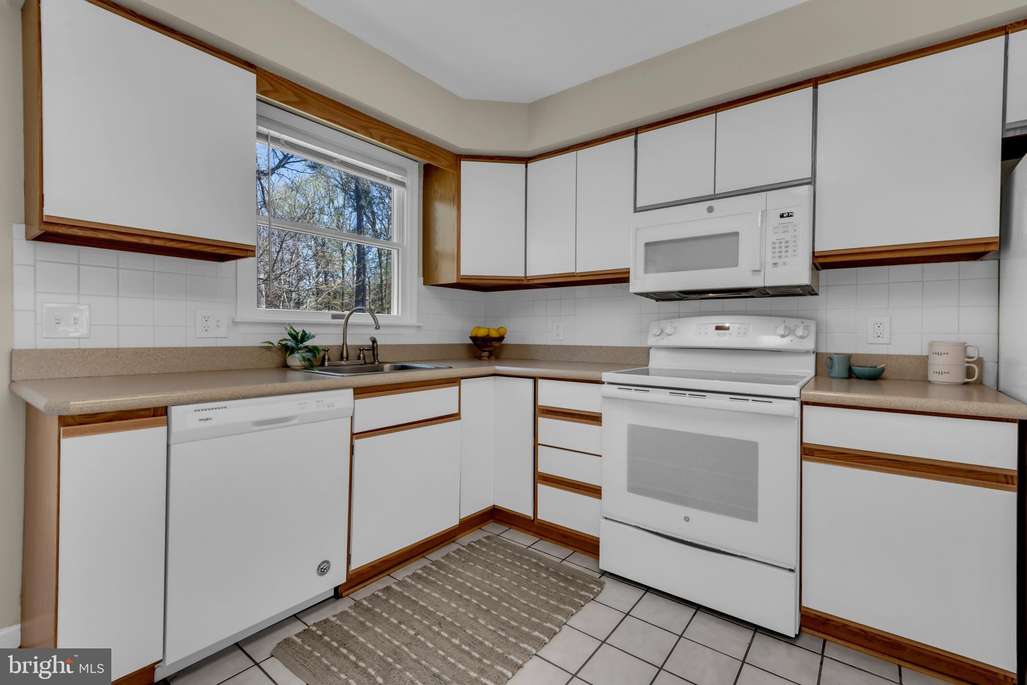 320 McKay Road Stevensville, MD 21666 - Photo 17 of 48 a kitchen with white cabinets stainless steel appliances and sink