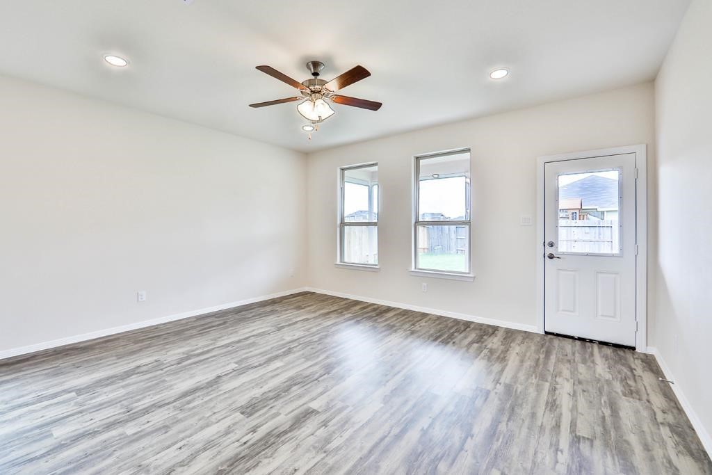 247 Sintra Lk Way Rosenberg, TX 77469 - Photo 13 of 28 wooden floor in an empty room with a window