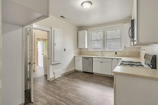 a kitchen with a sink white cabinets and white appliances