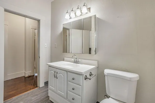 a bathroom with a sink toilet and mirror