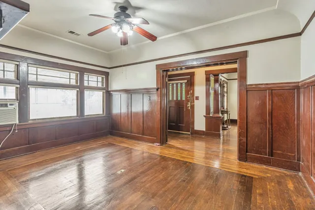 a view of empty room with wooden floor and fan