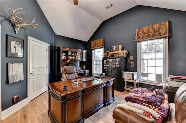 a kitchen with stainless steel appliances granite countertop a stove a refrigerator a sink a dining table and chairs with wooden floor