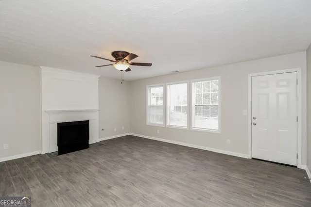 a view of an empty room with a fireplace and a window