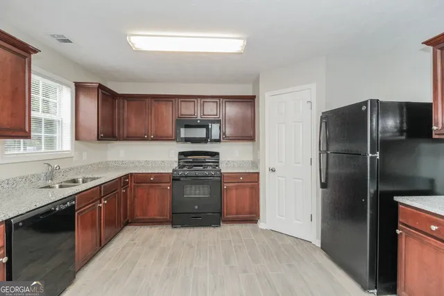 a kitchen with stainless steel appliances granite countertop a refrigerator stove and sink
