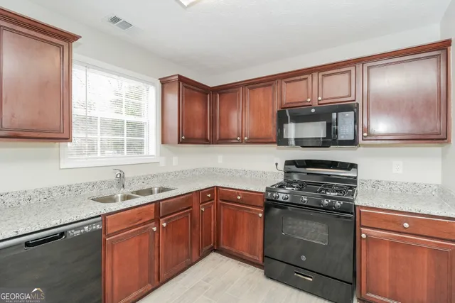 a kitchen with sink a microwave and cabinets