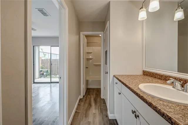 a bathroom with a granite countertop sink and a mirror