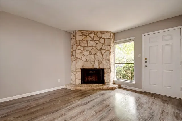 a view of an empty room with a fireplace and a window