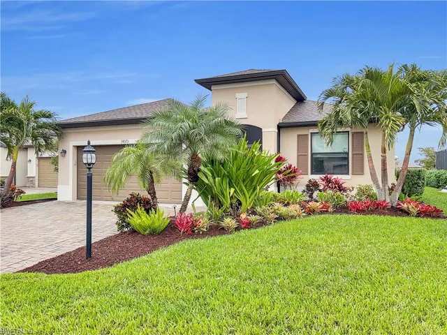 a front view of a house with a yard and potted plants