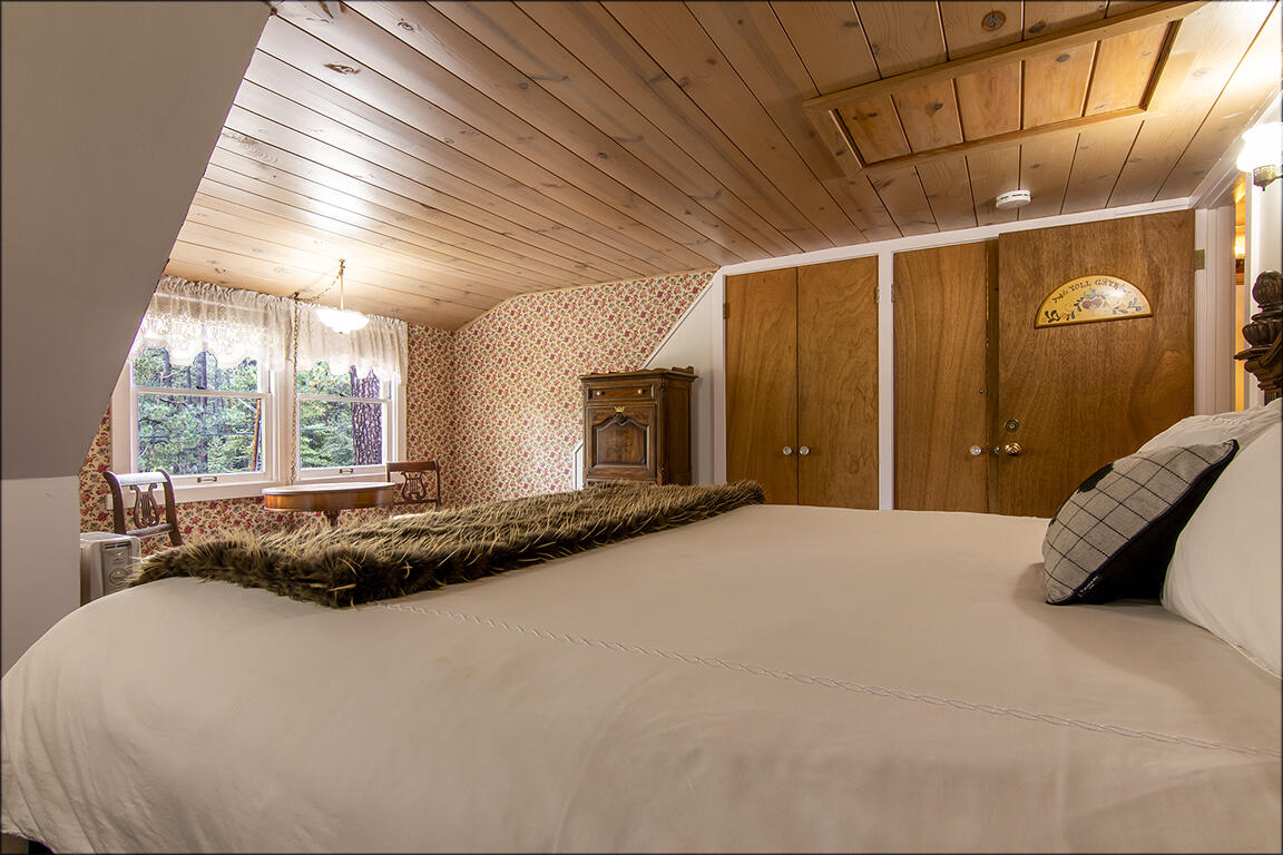 26770 Idyllwild Road Idyllwild, CA 92549 - Photo 19 of 52 a spacious bedroom with a bed and wooden floor