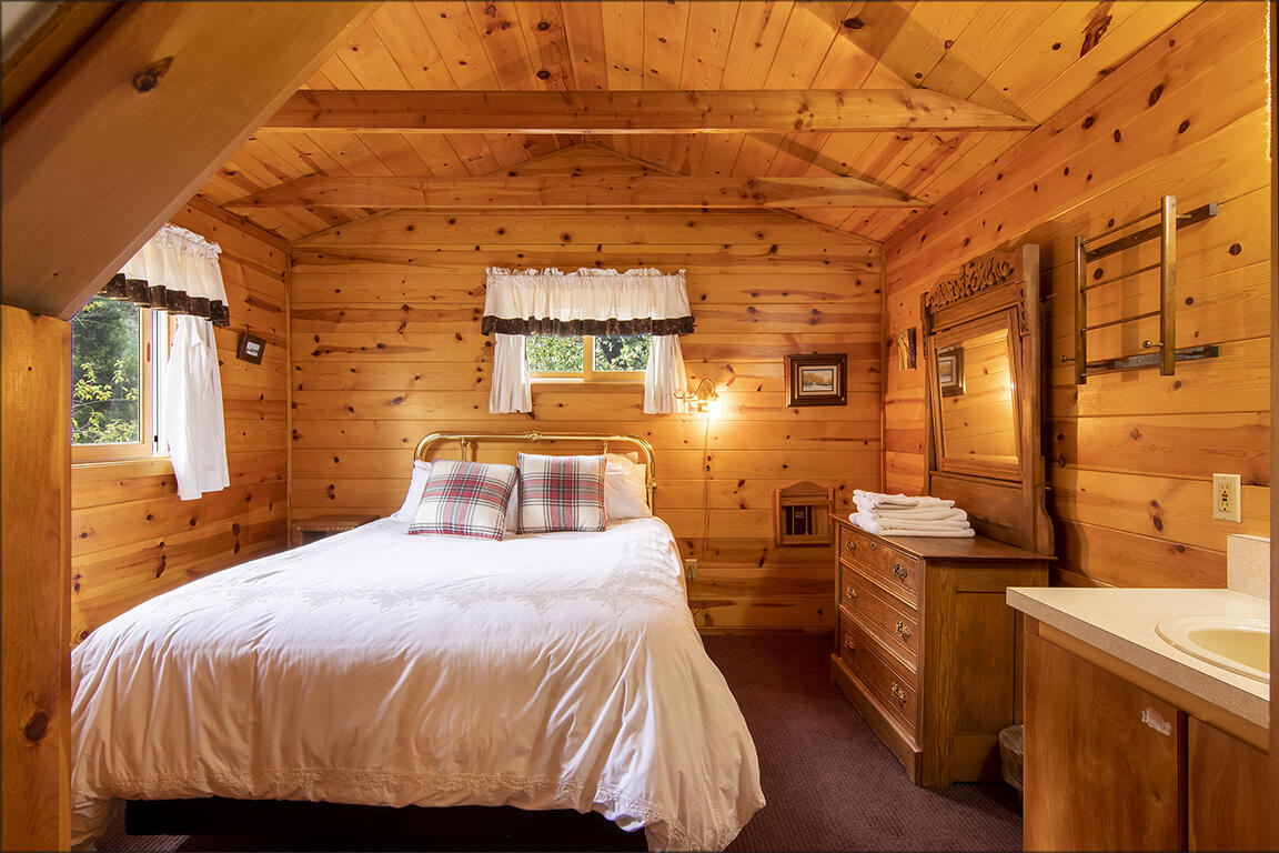26770 Idyllwild Road Idyllwild, CA 92549 - Photo 22 of 52 a bedroom with a bed and wooden floor
