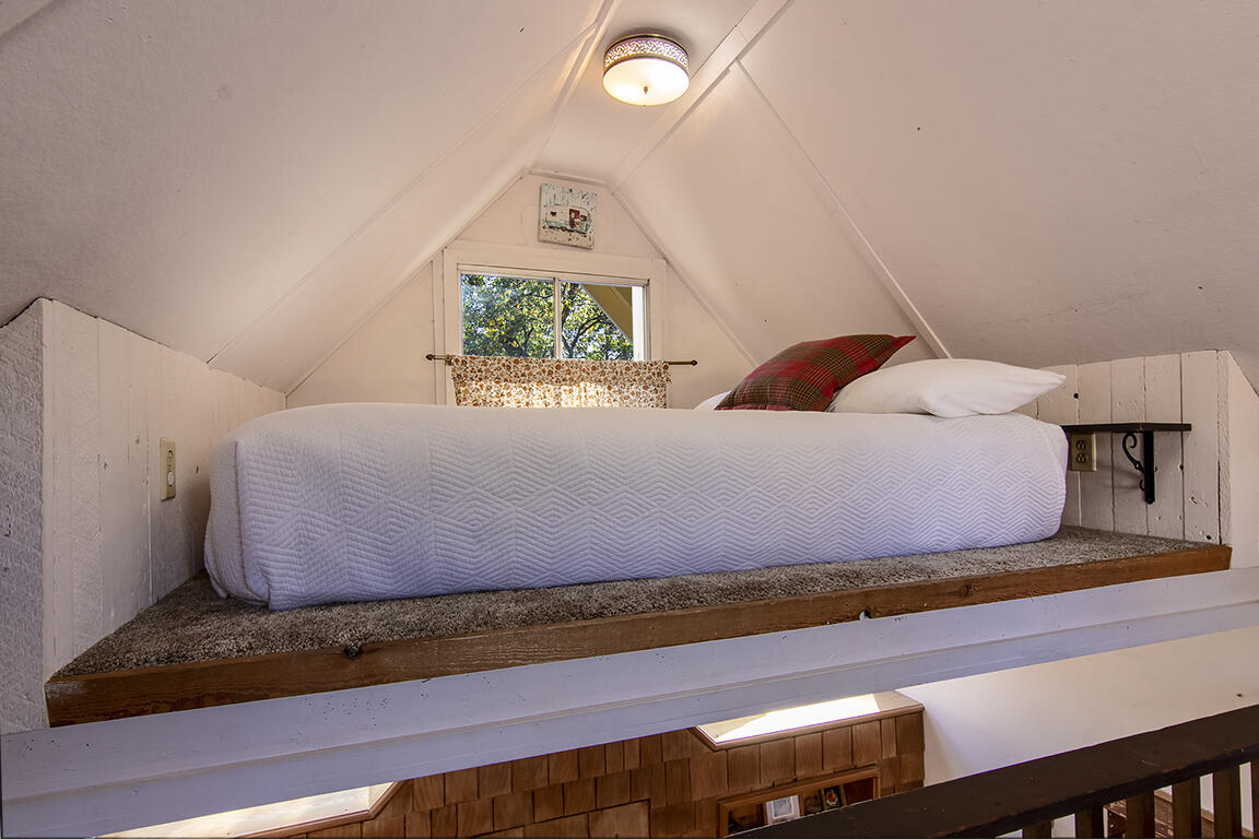 26770 Idyllwild Road Idyllwild, CA 92549 - Photo 37 of 52 a bedroom with a bed and a clock on dresser