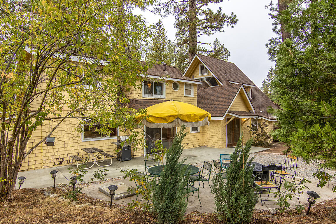 26770 Idyllwild Road Idyllwild, CA 92549 - Photo 51 of 52 a view of a white house with a swimming pool and lawn chairs under an umbrella