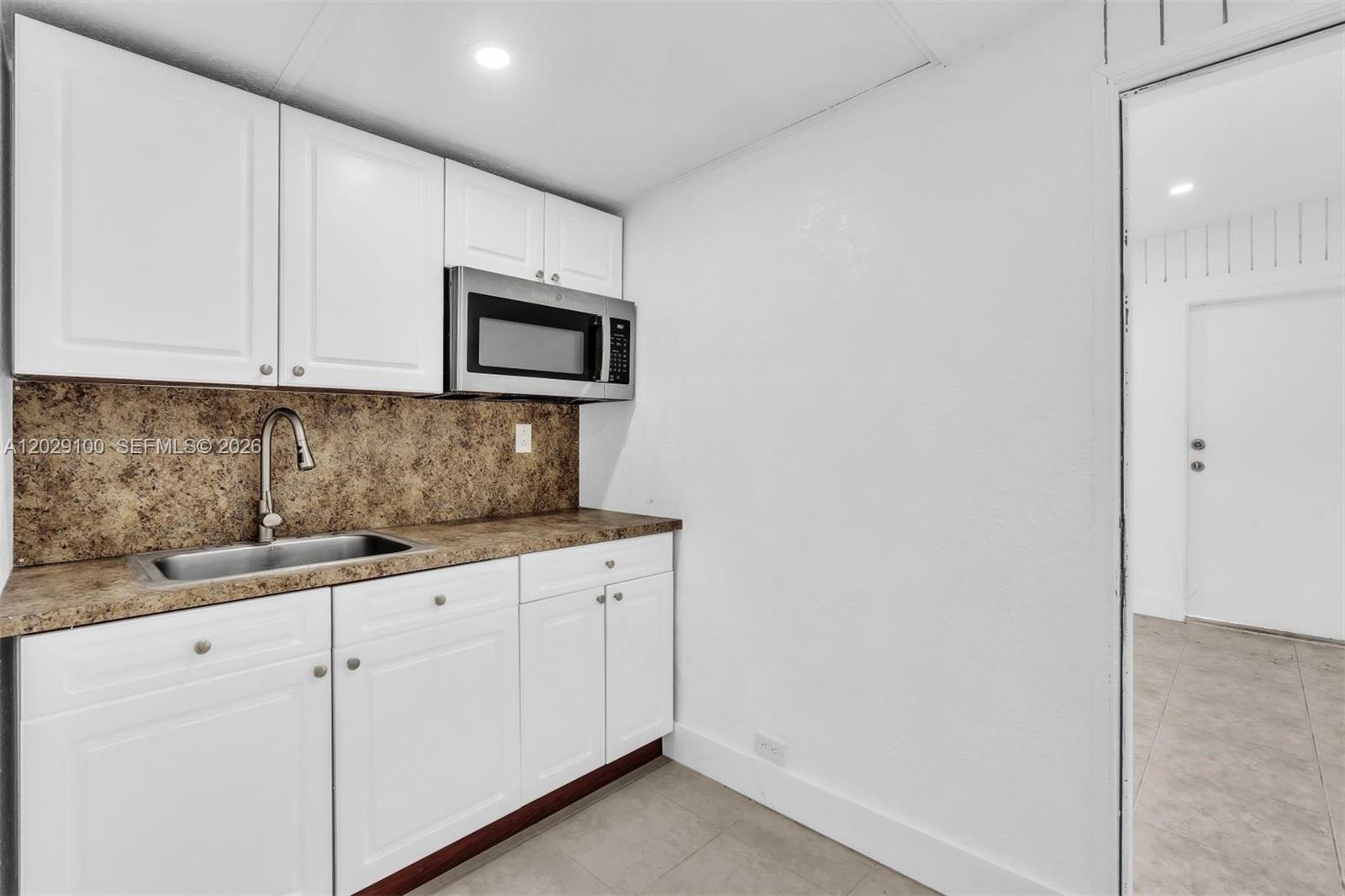 11790 Southwest 34th Street Miami, FL 33175 - Photo 23 of 56 a kitchen with granite countertop white cabinets and white stainless steel appliances