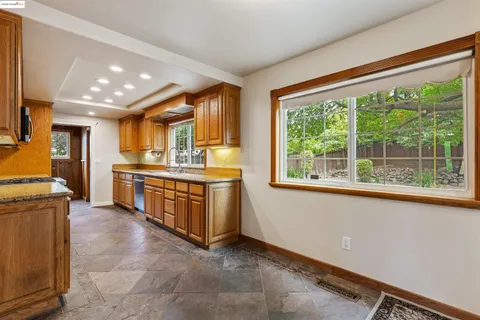 a kitchen with stainless steel appliances granite countertop a stove a sink and a refrigerator