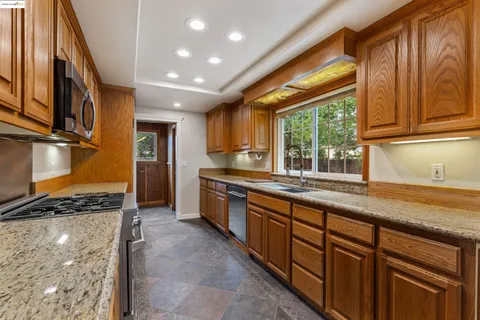 a kitchen with stainless steel appliances granite countertop a sink and cabinets