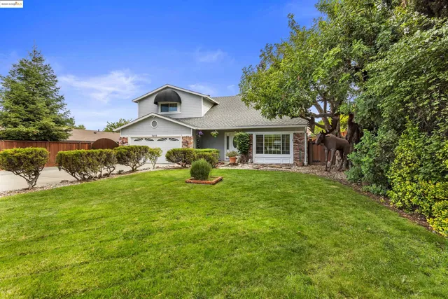 a front view of a house with a yard and potted plants