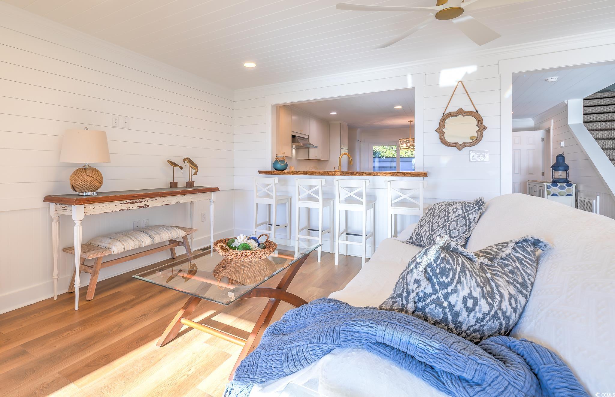 204 Bamboo Loop, Unit 202 Georgetown, SC 29440 - Photo 22 of 40 Living area with wood finished floors, stairs, crown molding, recessed lighting, and wooden walls