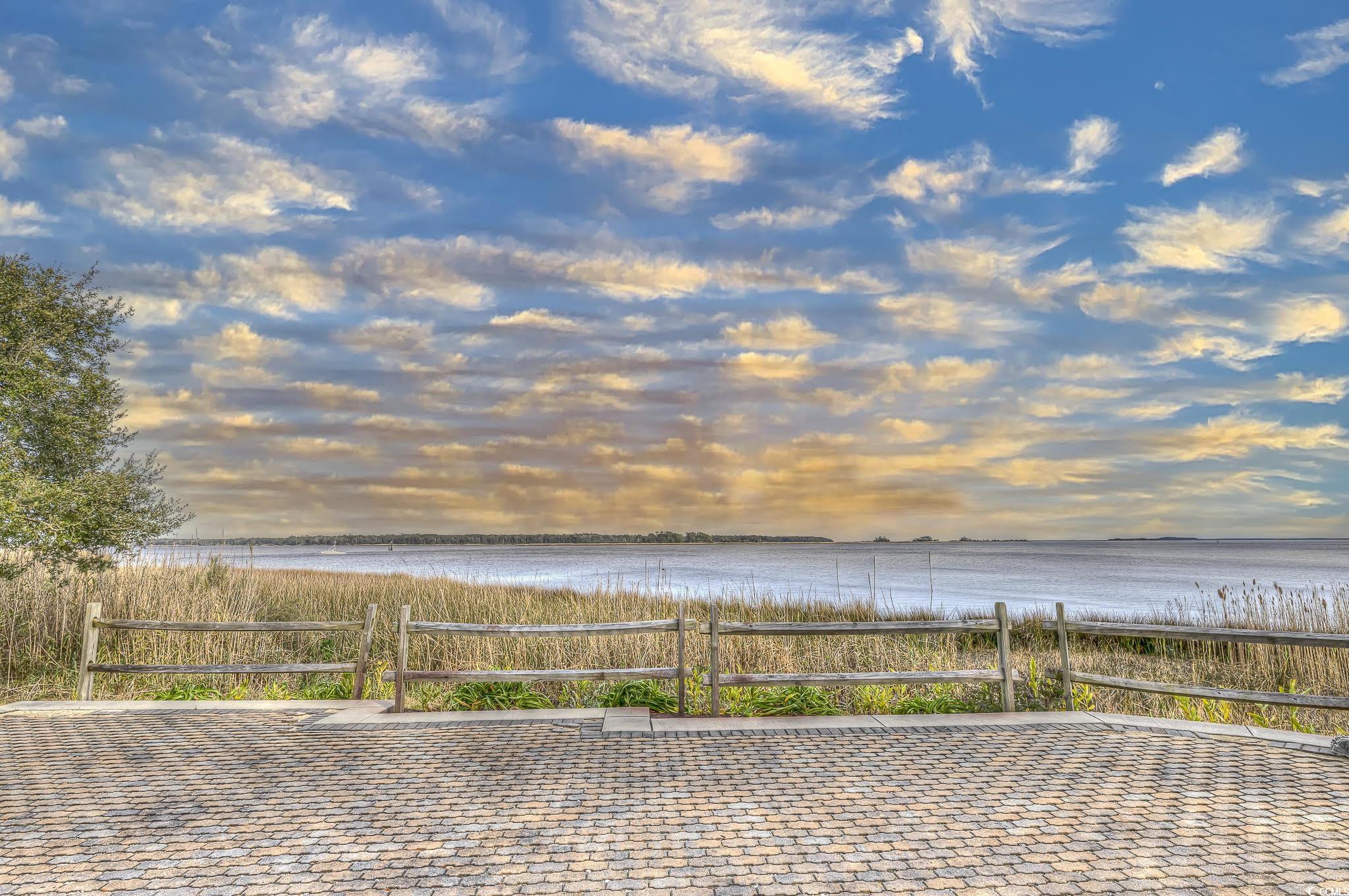 204 Bamboo Loop, Unit 202 Georgetown, SC 29440 - Photo 34 of 40 Patio terrace at dusk featuring a water view