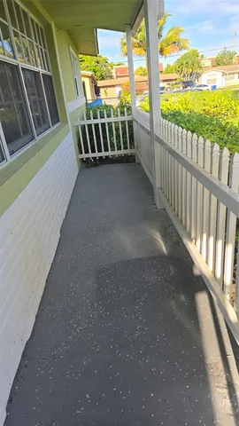 a living room with furniture a flat screen tv and kitchen view