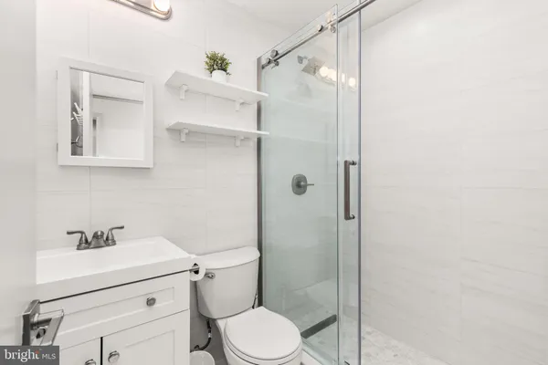 a bathroom with a sink mirror vanity and toilet