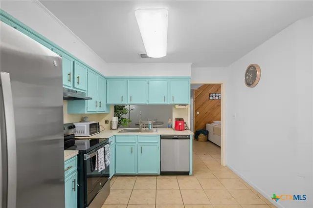 a kitchen with a refrigerator sink and cabinets