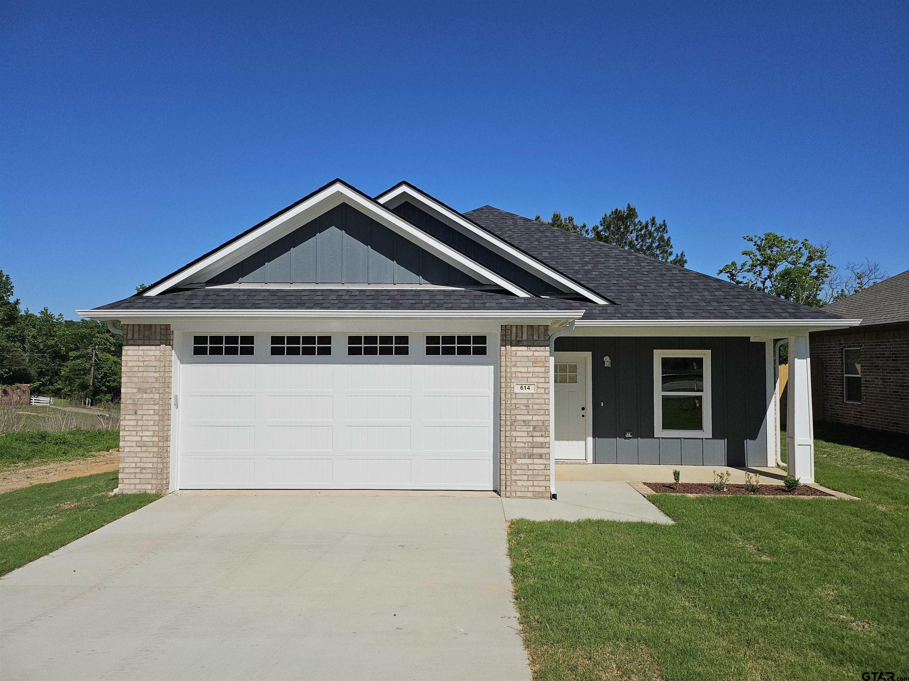 614 North Commerce Street Overton, TX 75684 - Photo 1 of 23 a front view of a house with a yard and garage