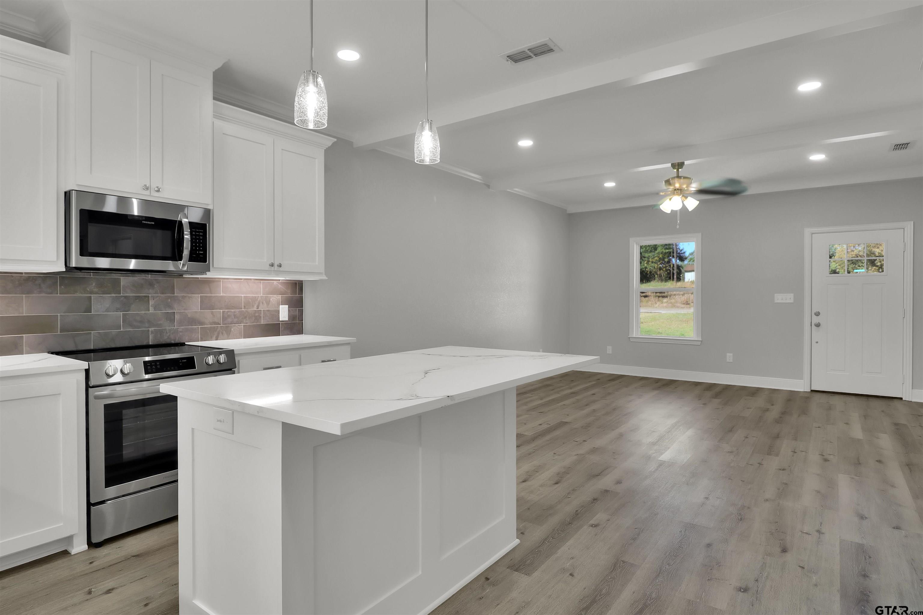 614 North Commerce Street Overton, TX 75684 - Photo 11 of 23 a kitchen with a stove and a microwave