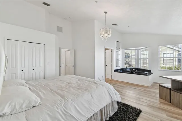 a spacious bedroom with a bed and a large window