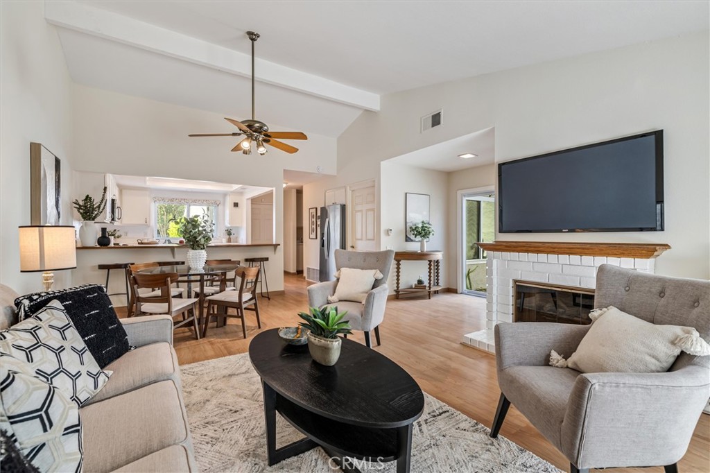 a living room with furniture a fireplace and a flat screen tv