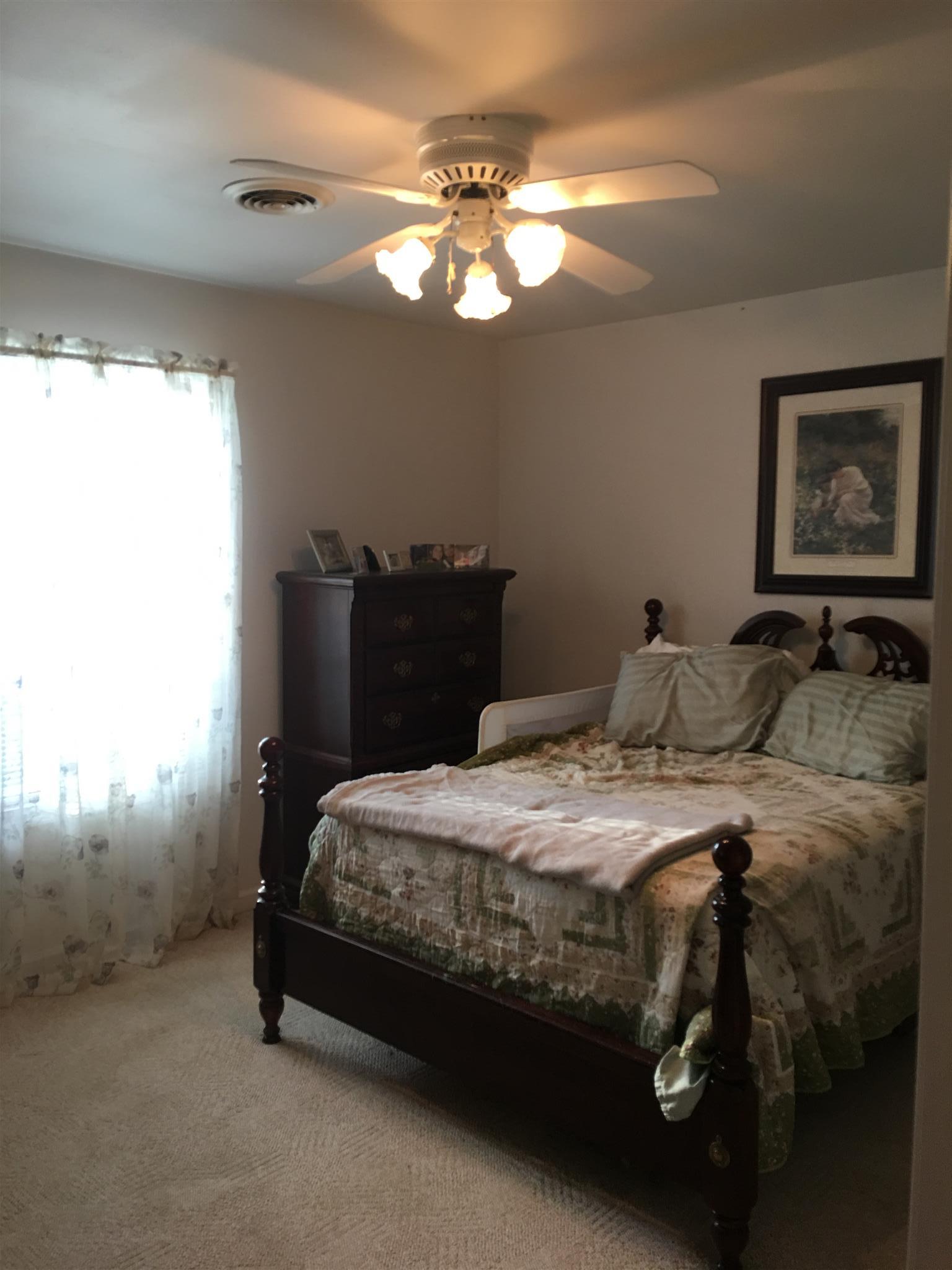 1241 Cheyenne Boulevard Madison, TN 37115 - Photo 12 of 16 a bedroom with a bed and a chandelier