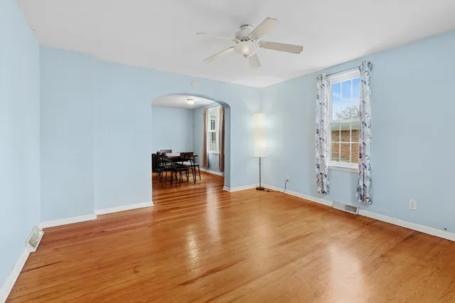 a view of an empty room with window and wooden floor
