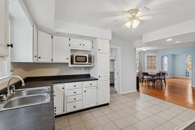 a kitchen with stainless steel appliances a sink a stove a table and chairs
