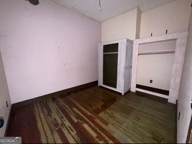 a view of an empty room with closet and a window