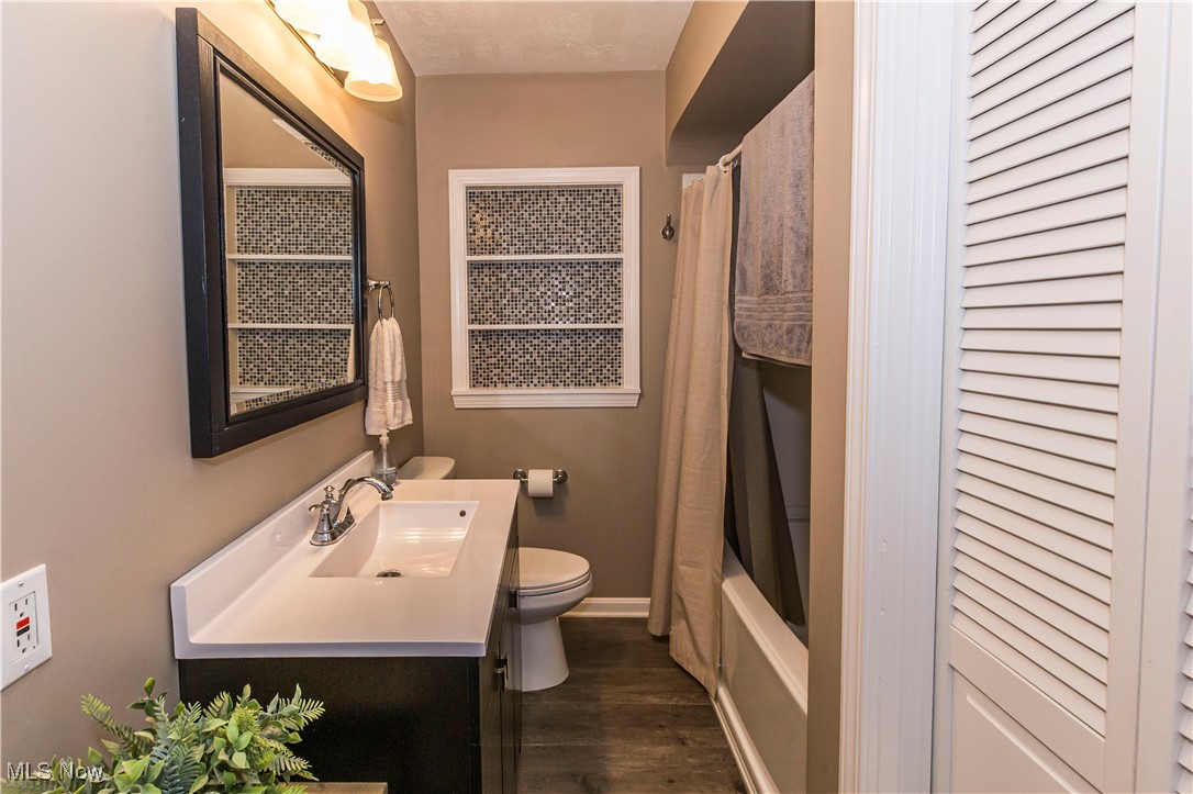 2430 Rockside Road Independence, OH 44131 - Photo 20 of 46 Full bathroom featuring vanity, dark wood-style floors, shower / tub combo with curtain, and a closet