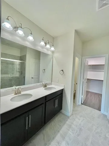 a bathroom with a double vanity sink and a mirror