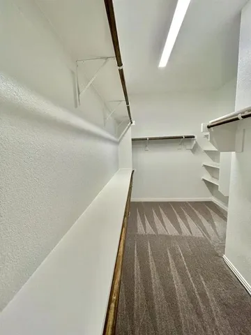 a view of walk in closet with empty racks