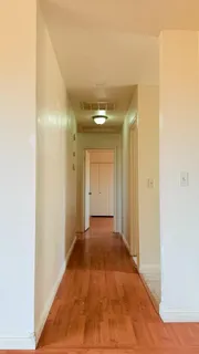 a view of a hallway with wooden floor