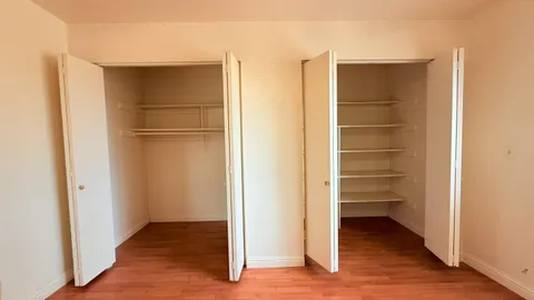 a view of walk in closet with empty racks