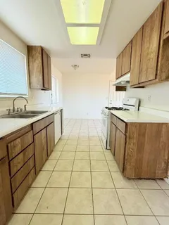a kitchen with a sink a stove and cabinets
