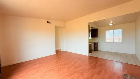 a view of empty room with wooden floor and fireplace