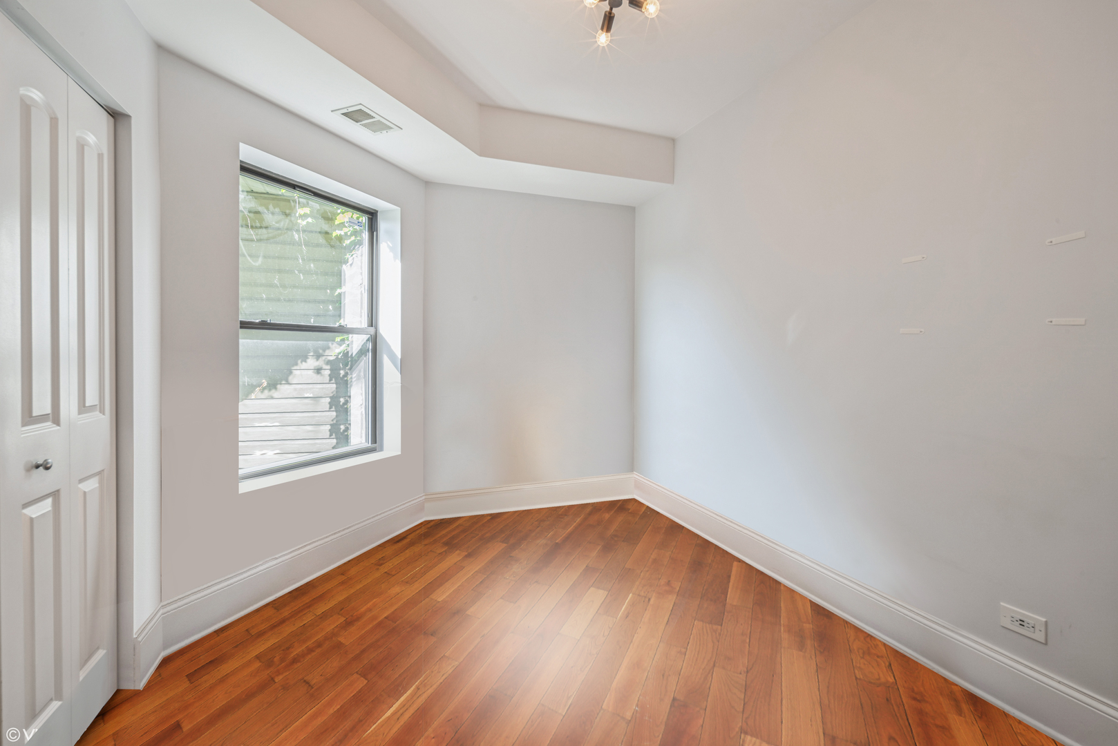 4819 South Prairie Avenue, Unit 2 Chicago, IL 60615 - Photo 7 of 10 an empty room with wooden floor and windows