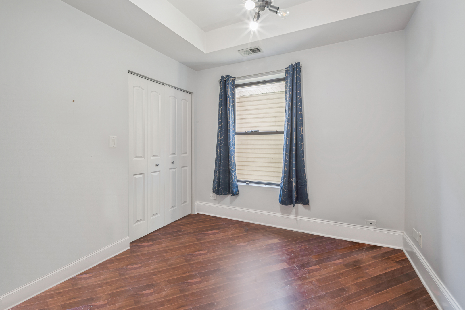 4819 South Prairie Avenue, Unit 2 Chicago, IL 60615 - Photo 8 of 10 an empty room with wooden floor and windows