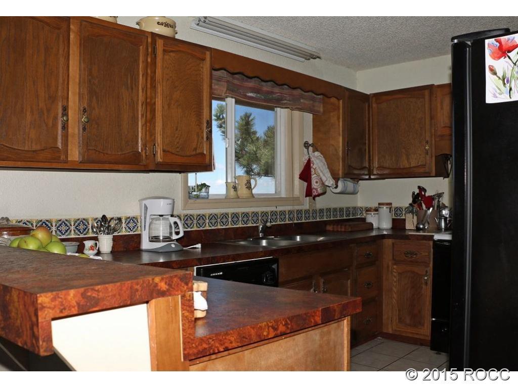 159 Kankakee Road Westcliffe, CO 81252 - Photo 4 of 22 a kitchen with granite countertop a sink cabinets and stainless steel appliances
