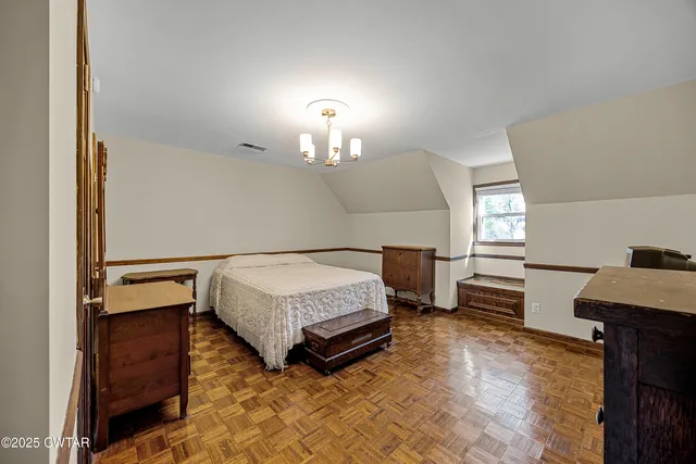 a bedroom with a bed and a dresser next to a window