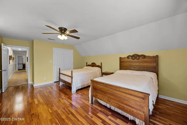 a bedroom with bed and wooden floor