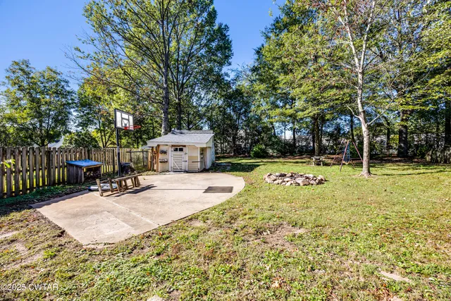 a view of a swimming pool with a bench and trees