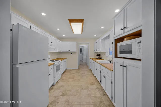 a kitchen with white cabinets and white appliances