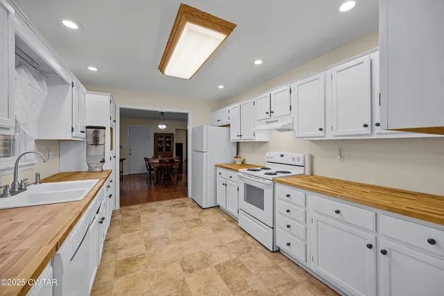 a large kitchen with stainless steel appliances granite countertop a sink and cabinets