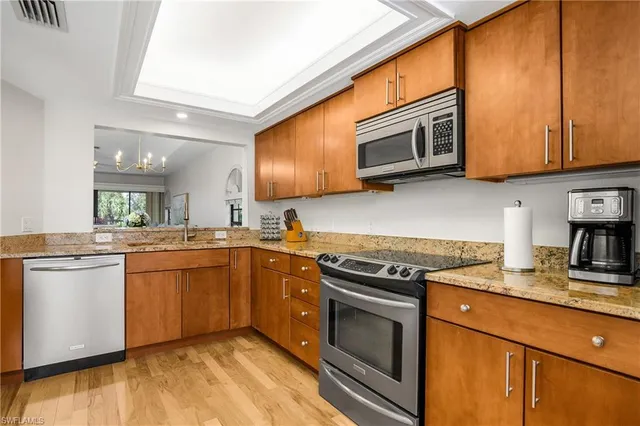 a kitchen with stainless steel appliances granite countertop a stove microwave and sink