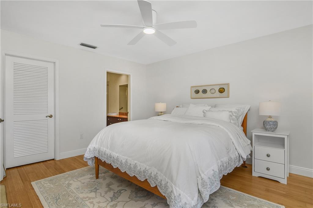 701 Augusta Boulevard, Unit 7018 Naples, FL 34113 - Photo 15 of 30 a bedroom with a bed and wooden floor